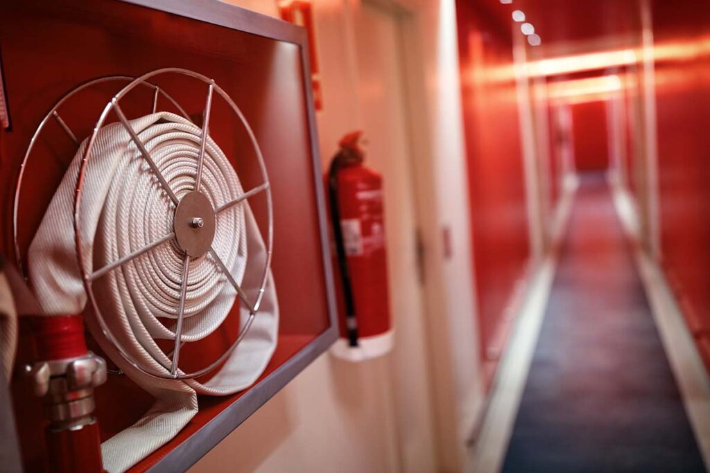 Fire extinguisher and fire hose reel in corridor
